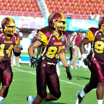 three football players on Marauder Field