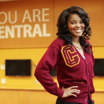 central state university student Asia Fuqua wearing maroon and gold beside a sign saying you are central