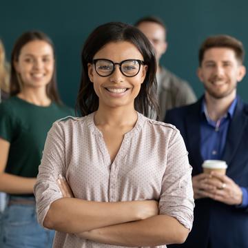 a group of professionals with a young African American woman in glasses smiling in front