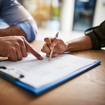 two people review paperwork on a clipboard