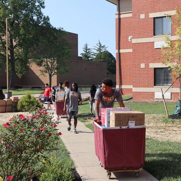 a central state university student pushing a cart with belongings during move-in day