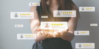 A person holds in their open hands an image of an online rating with five stars