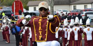 A member of the Invincible Marching Marauders of Central State University points at the camera
