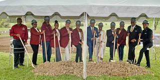 A group of people stands under a tent with a pile of dirt in front of them. They are holding shovels in preparation to break ground on a new research facility at Central State University.