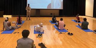 eight Black students sit on yoga mats during a mindfulness session sponsored by Central State University Counseling Services