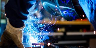 A person welds while wearing safety equipment