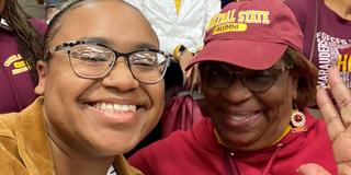 A young woman with her grandmother in Central State University attire of maroon and gold