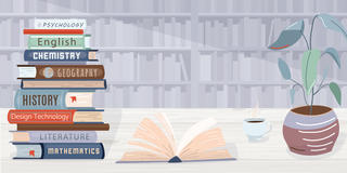 Stack of textbooks next to an open book and potted plant