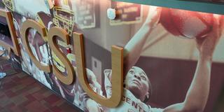 Wall painting showing a Central State University women's basketball player taking a shot. The letters CSU appear in gold.