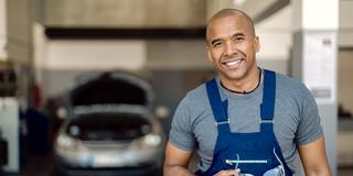 A mechanic holding safety glasses in an auto repair shop