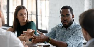 an employee participates in a training discussion while peers look on