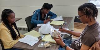 Students Mahogany Chapman, Raven Arnold, and Marcus Steel create an evidence log for their Crime Scene Analysis course at Central State University