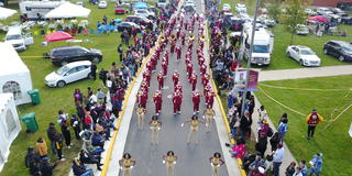 aerial photo above the Homecoming parade with the Invincible Marching Marauders and the Auxiliary Corps