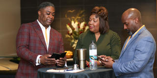 three people network at the inaugural rise to the challenge summit in 2022