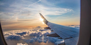 Over-wing view of clouds from airplane window seat.