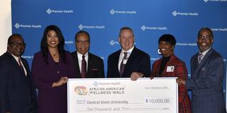 representatives from Central State University and Premier Health holding a large check for $10,000 in proceeds from the annual African American Wellness Walk in Dayton, Ohio