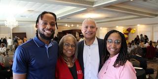 a young African American man stands with his mother and grandparents during the central state university cincinnati star alumni chapter's annual scholarship luncheon