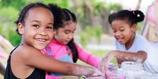 three young people explore science during a summer camp