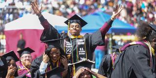 central state university graduate raises arms in celebration