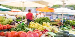 vegetables in the foreground of a farmers market