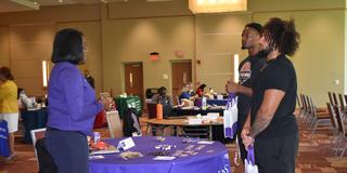 two central state university student-athletes stop by a des moines medical school table in the university student center