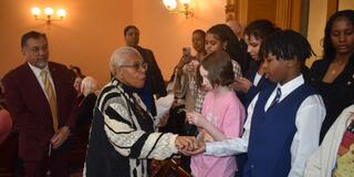paula hicks-hudson passes out souvenirs to 4-H youth urban farmers