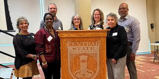 seven panelists stand around a podium at the soar summit at central state university