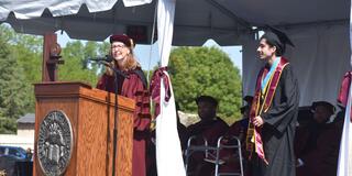 tristin fernandes and doctor amy hobbs harris on stage at the 2025 commencement ceremony at central state university