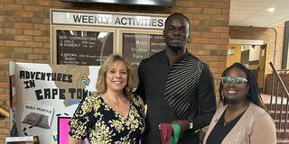 doctors theresa aikens and sarah armstrong-jones stand next to ibrahima jarjou holding honors medallions