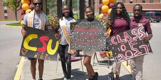 five Central State University students hold signs welcoming the class of 2027 to campus