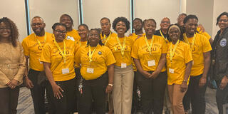 large group of people wearing gold shirts and lanyards