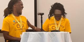 myles calhoun and dr. sonia hunt share a laugh on stage
