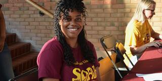 a young woman in a central state university t-shirt smiles at the camera