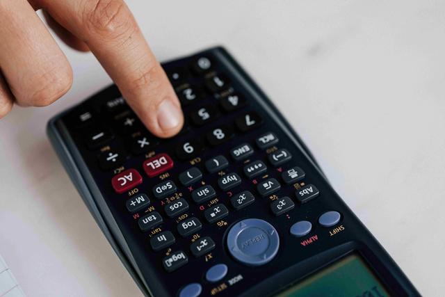 a person points at a calculator