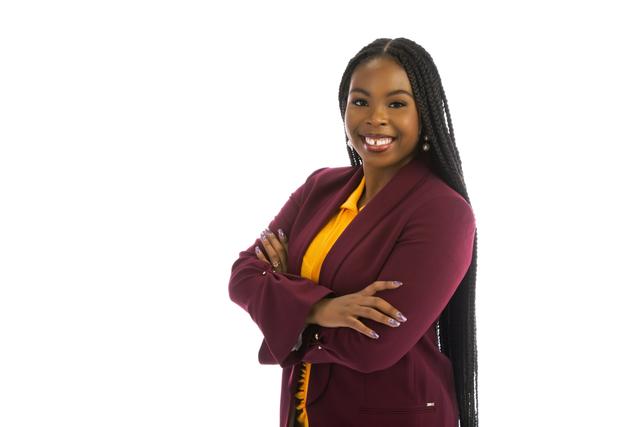 A young Black woman with long black hair wears Central State University colors of maroon and gold