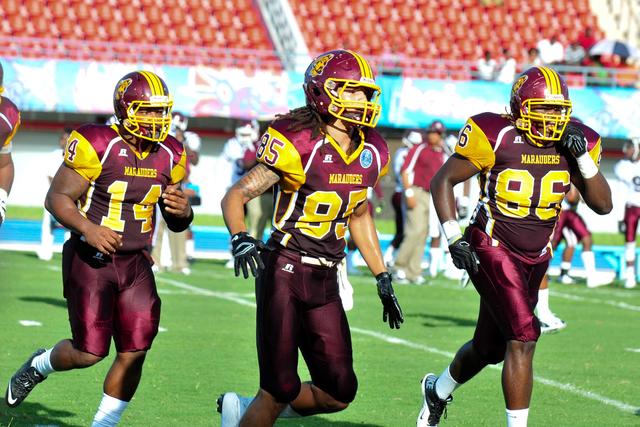 three football players on Marauder Field