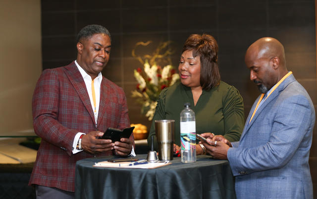 three people network at the inaugural rise to the challenge summit in 2022