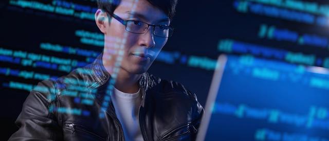 a student studying computer science at a laptop with transparent code overtop