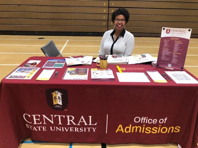 Central State University recruiter Ashley Clarke sits at an Office of Admissions table during a recruiting event