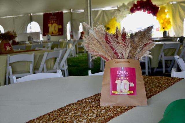 table decoration in a large tent with features and message on the 10th anniversary of the central state university land-grant program