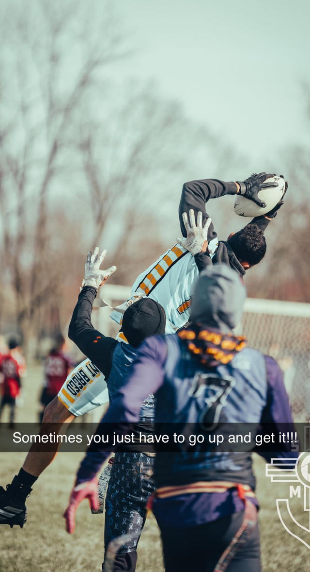 a young Black man catches a football while others look on and a caption added saying sometimes you just have to go up and get it