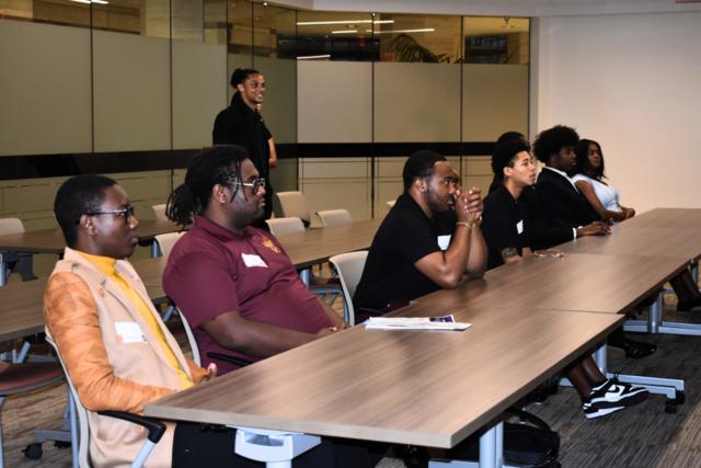 daquan neal stands behind a group of students during a panel discussion with ohio legislature members
