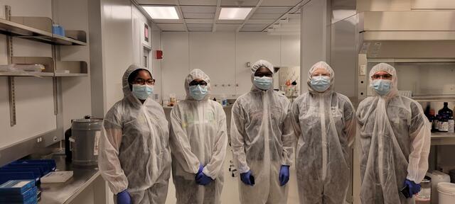 semiconductor summer interns in a lab wearing protective gear and lab coats