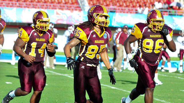 three football players on Marauder Field