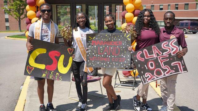 five Central State University students hold signs welcoming the class of 2027 to campus