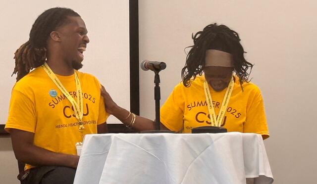 myles calhoun and dr. sonia hunt share a laugh on stage