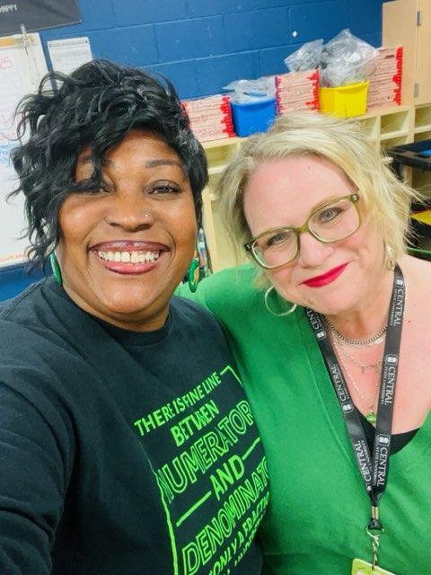 a white woman and an african american woman stand together with their arms around each other
