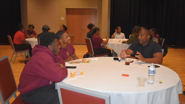 three men sit at a table in the central state university student center