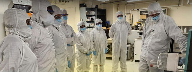 Semiconductor Certificate Program students in full cleanroom attire observe a lab demonstration at a semiconductor fabrication facility
